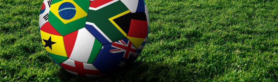 Soccer ball with world flags on grass field