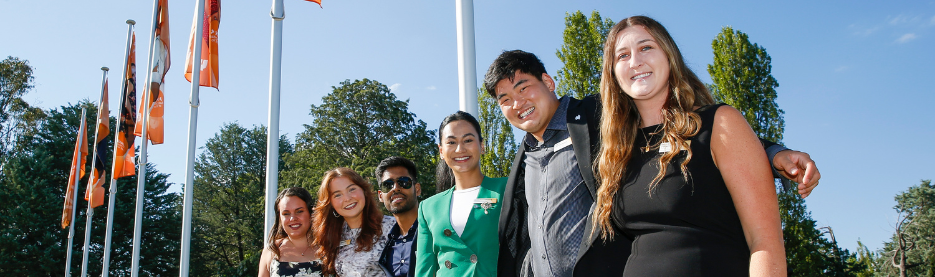 Smiling group standing near flags outdoors