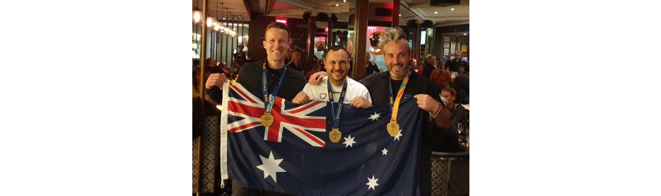 Three men celebrating with Australian flag and medals