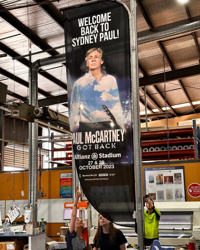 Flagworld staff checking a Paul McCartney banner at the Mulgrave factory